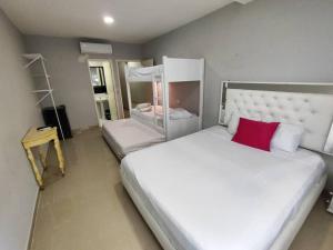 1 dormitorio con cama blanca grande y almohada roja en CASA BELLAMARE, en Cartagena de Indias