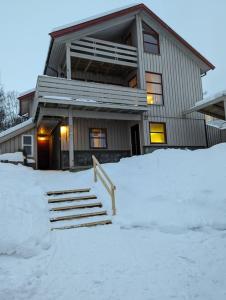 a house with a pile of snow in front of it at Koselig leilighet nær bussholdeplass og natur. in Tromsø