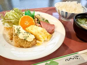 Hotel Happy Holiday Ishigakijima - Vacation STAY 04124v في جزيرة إيشيغاكي: طبق من طعام الإفطار مع بيض ولحم وخضروات