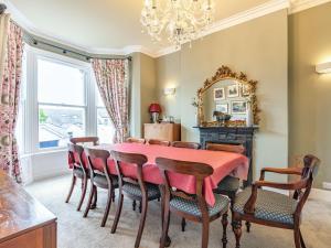 a dining room with a table and chairs and a mirror at Eversley in Llandudno