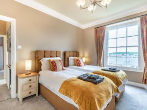 two beds in a bedroom with a window at Eversley in Llandudno