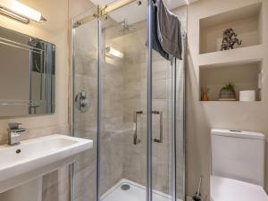 a bathroom with a shower and a sink and a toilet at Eversley in Llandudno +22 photos