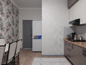 a kitchen with a refrigerator and a table and chairs at Квартира in Shymkent