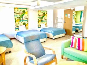Zimmer mit 3 Betten, einem Stuhl und einem Sofa in der Unterkunft Hotel Happy Holiday Ishigakijima - Vacation STAY 04026v in Ishigaki-jima