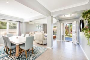 a dining room and living room with a table and chairs at Bluewater Jervis Bay - Pet Friendly with Spa in Callala Beach