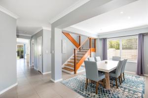 a dining room with a table and chairs and a staircase at Bluewater Jervis Bay - Pet Friendly with Spa in Callala Beach