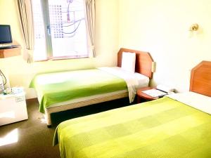 a hotel room with two beds and a window at Hotel Happy Holiday Ishigakijima - Vacation STAY 04135v in Ishigaki Island