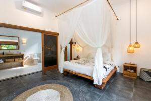 um quarto com uma cama e uma rede mosquiteira em Unicorn Shelter Villa em Seminyak