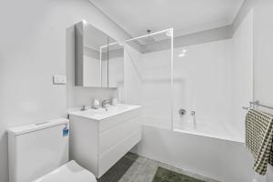ein weißes Bad mit einem WC und einem Waschbecken in der Unterkunft Mirror Bay in Laurieton