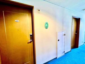 ein Flur mit zwei Türen und einer Uhr an der Wand in der Unterkunft Hotel Happy Holiday Ishigakijima - Vacation STAY 04140v in Ishigaki-jima