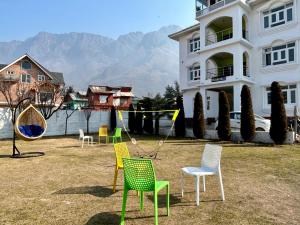 um grupo de cadeiras em frente a um edifício em Whostels Srinagar em Srinagar