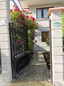 una entrada a una casa con una puerta negra con flores en Villa Detelina Balchik, en Balchik