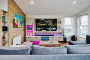 sala de estar con 2 sofás y TV de pantalla plana en C-Scape Lodge en Newquay