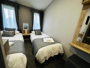 Habitación de hotel con 2 camas y 2 ventanas en C-Scape Lodge en Newquay