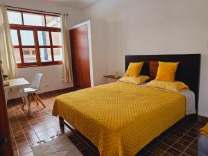 1 dormitorio con 1 cama con edredón amarillo en Miski Rumi., en Huaycán Alto