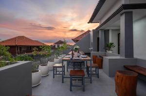 un patio con tavolo e sedie sul balcone. di Verdant Bali Sekar Sari a Denpasar