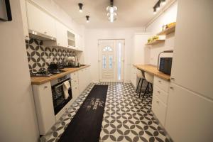 a kitchen with white cabinets and a black and white floor at RITM Apartament in Blaj