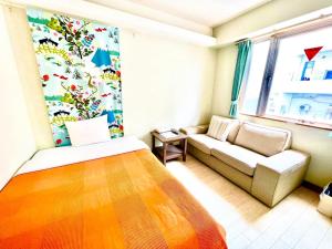 ein kleines Zimmer mit einem Bett und einer Couch in der Unterkunft Hotel Happy Holiday Ishigakijima - Vacation STAY 04143v in Ishigaki-jima