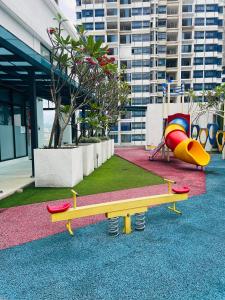 een speeltuin met een bank en een glijbaan bij Reizz Residence By D'Amour in Kuala Lumpur