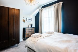 a bedroom with a bed and a dresser and a window at Stay with airhgt at 3 bedroom house near The Stray in Harrogate