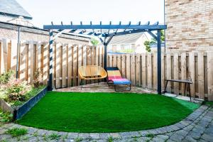 a garden with a chair and a pergola and grass at Stay with airhgt at 3 bedroom house near The Stray in Harrogate