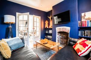 Sala de estar azul con sofá y chimenea en Stay with airhgt at 3 bedroom house near The Stray en Harrogate