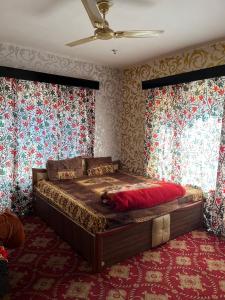 - une chambre avec un grand lit dans une pièce avec du papier peint dans l'établissement Hotel Kashmir Heaven, à Srinagar