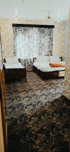 シュリーナガルにあるHotel Kashmir Heavenのカーペットフロアのドミトリールーム ベッド2台