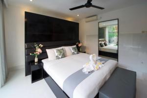 een slaapkamer met een groot wit bed en een grote spiegel bij Seminyak Sky-Villa 3-8 BR Brilliant Location from Beach to Shopping in Seminyak