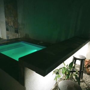 a swimming pool in a room with a table and a stool at Alina's House in Fortuna