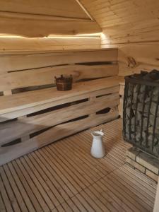 una sauna con un jarrón blanco en el suelo de madera en Wilcza Jama - domki z bali, en Lutowiska