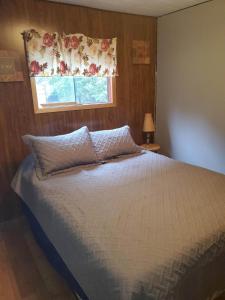 a bedroom with a bed with a window and a bedspread at The Cove in Little Current