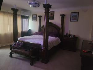 1 dormitorio con 1 cama grande con marco de madera en Ocean View Penthouse, en Boca Chica