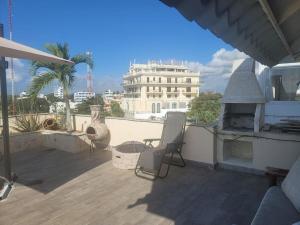 a patio with two chairs and a fireplace on a roof at Ocean View Penthouse in Boca Chica