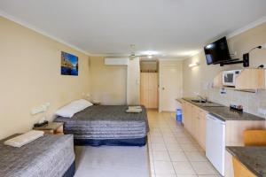 Habitación de hotel con 2 camas y cocina en Tambo Mill Motel & Caravan Park, en Tambo