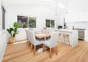 a kitchen and dining room with a wooden table and chairs at Southcape, Gerroa in Gerroa