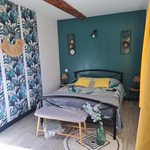 um quarto com uma cama e uma parede azul em Le Domaine Vesque em Saint-Pierre-de-Clairac