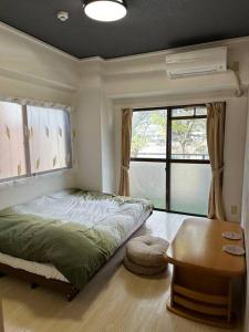 um quarto com uma cama, uma mesa e uma janela em North River 203 Blue Lotus スタジアムEdon Peace Wingの近く em Kami-nagarekawachō