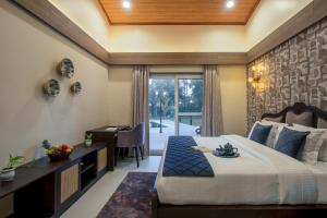 a bedroom with a large bed with a desk and a desk at Elivaas Esh Luxe 5BHK Villa with Private Pool near Gurgaon in Gurgaon