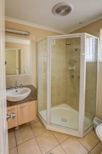 a bathroom with a shower and a sink at Tambo Mill Motel & Caravan Park in Tambo