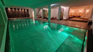 a swimming pool with green water in a house at Hotel Rheinischer Hof in Garmisch-Partenkirchen