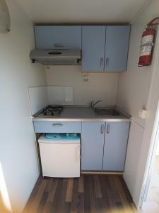 a small kitchen with a sink and a stove at Hillbilly cabin, 2 studios in nature with terrace and parking in Skiathos