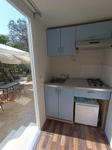 a kitchen with a sink and a stove at Hillbilly cabin, 2 studios in nature with terrace and parking in Skiathos