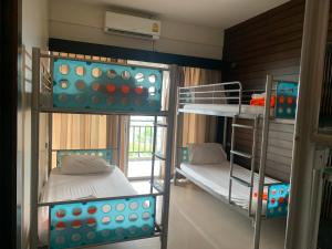 a room with two bunk beds and a window at Lub Sbuy Hostel in Phuket Town