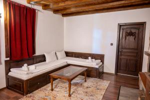Sala de estar con 2 camas y mesa en Rhodopes Legends, en Vrata