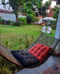 a hammock with red and black cushions in a yard at EusebioCity in Eusébio