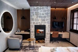 a living room with a fireplace and a tv at Rhodopes Legends in Vrata