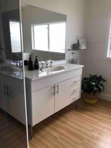 a bathroom with two sinks and a large mirror at Marjalis Cottage, your perfect country getaway! in Wonthaggi