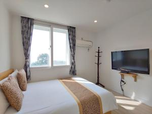 a bedroom with a bed and a flat screen tv at Star House in Jeju