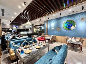 a restaurant with blue couches and tables in a room at HUSMA Hotel & Spa in Tashkent
